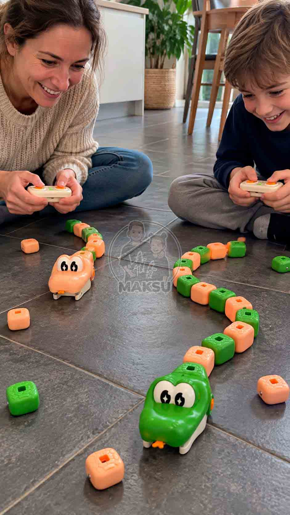 Mom and son laughing on the kitchen floor while racing green and cream remote control magnetic snakes